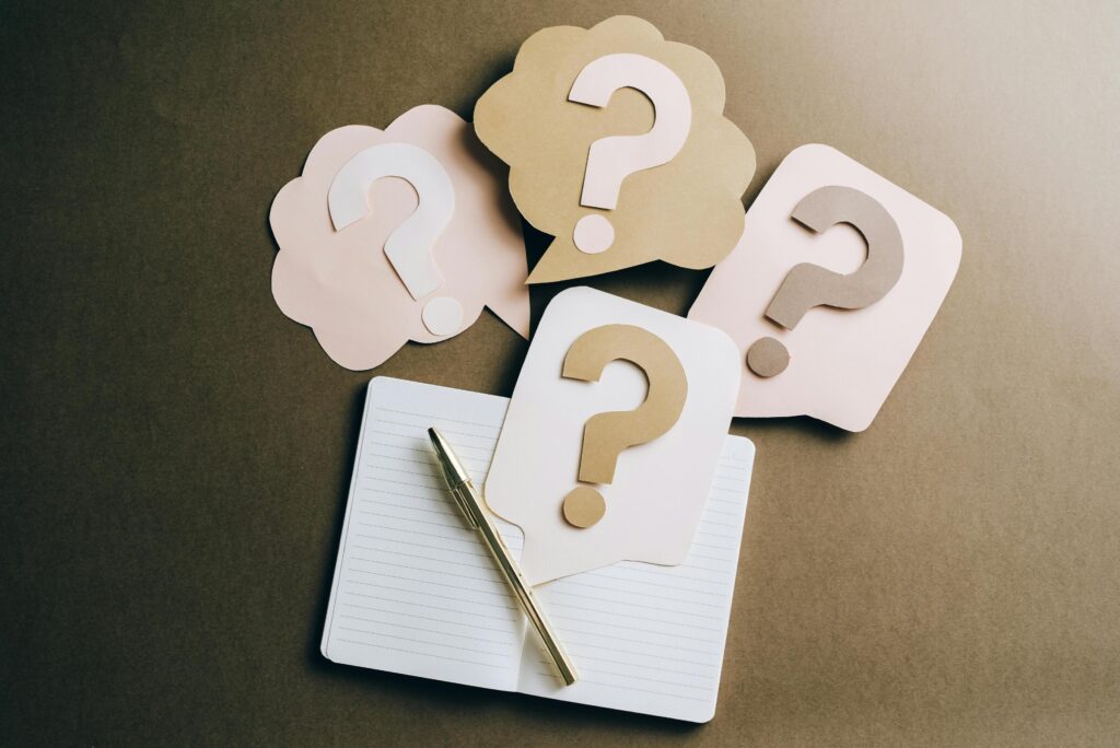 Cards showing question marks next to a pencil and paper for a quiz