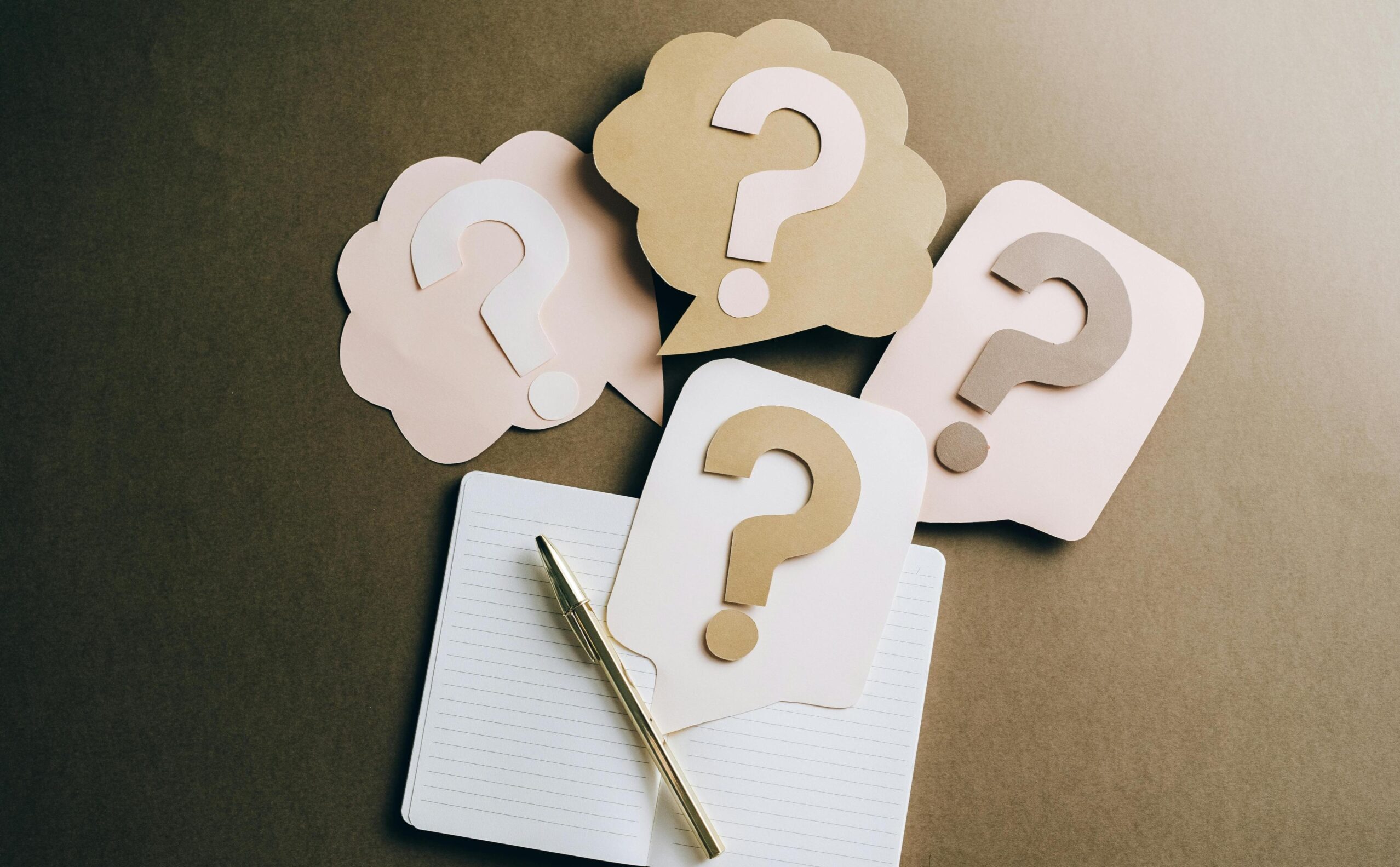 Cards showing question marks next to a pencil and paper for a quiz