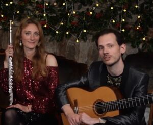Emily of Andrews Masse duo in a red sequinned top sits in front of stars