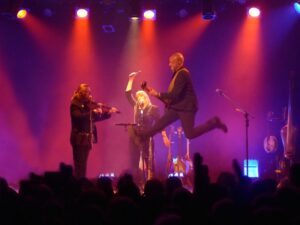 A singer jumps in the air during a performance by the Churchfitters