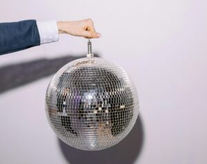 A glitter ball swings as it is held in place at a silent disco