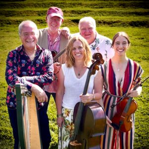 A group of musicians smile as they hold their instruments